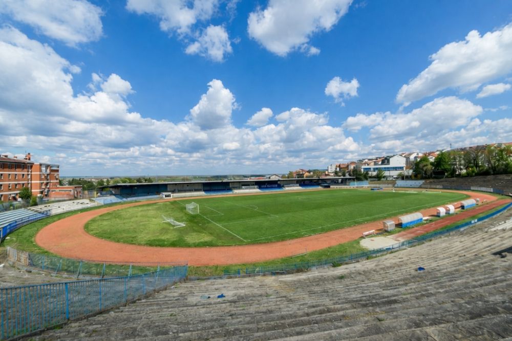 Fudbalski stadion u manjem gradu sa atletskom stazom i tribinama